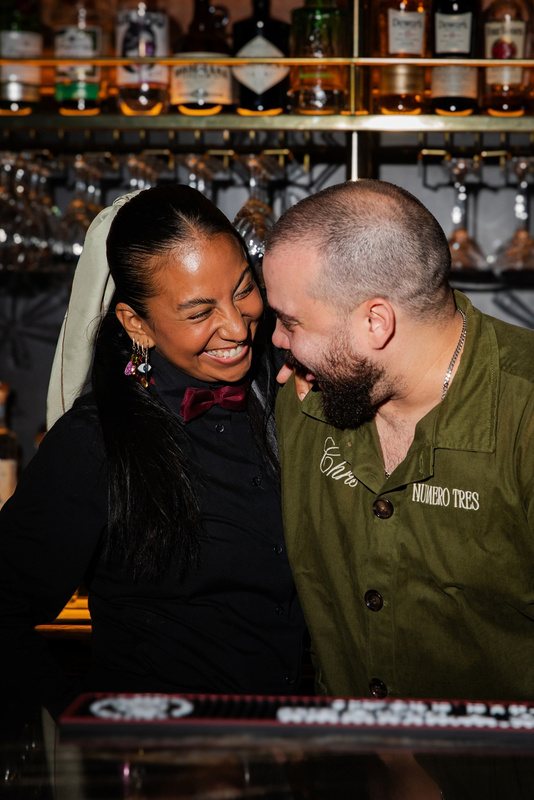 Bartender and guest sharing a laugh at the bar