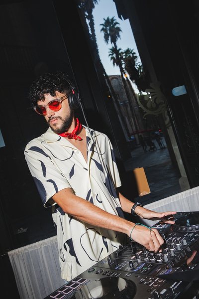 DJ in sunglasses spinning on the terrace