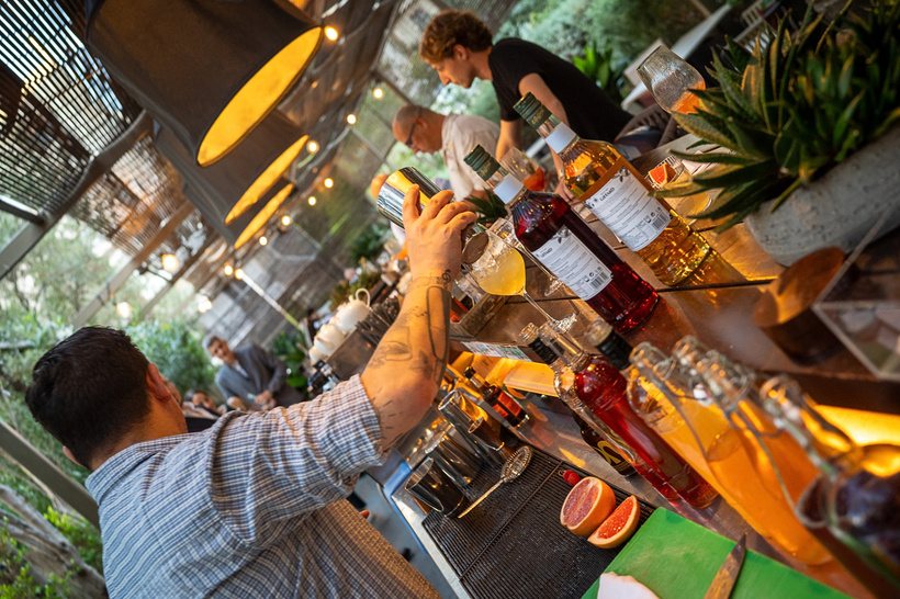 Bartender pouring over a crowded bar top