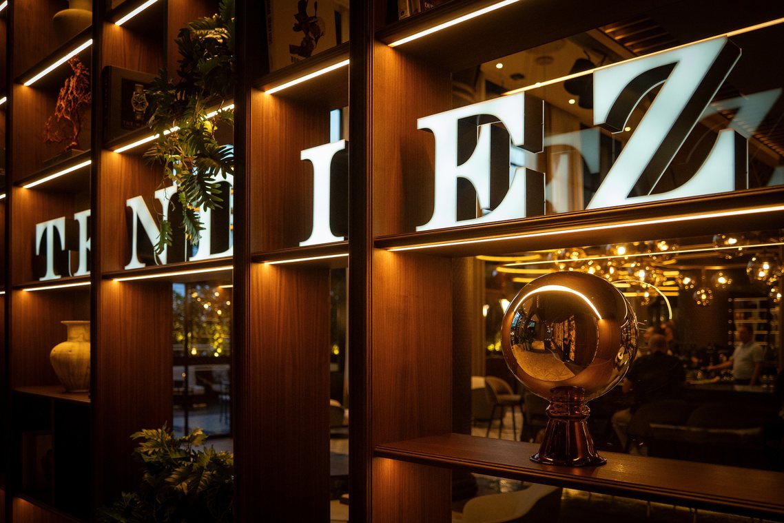 Illuminated Tendiez lettering over a warm backbar