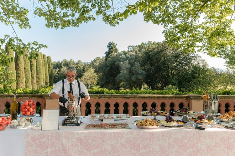 Carving station on a garden terrace framed by cypress trees