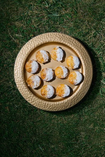 Brass tray of sugared pastries on the grass