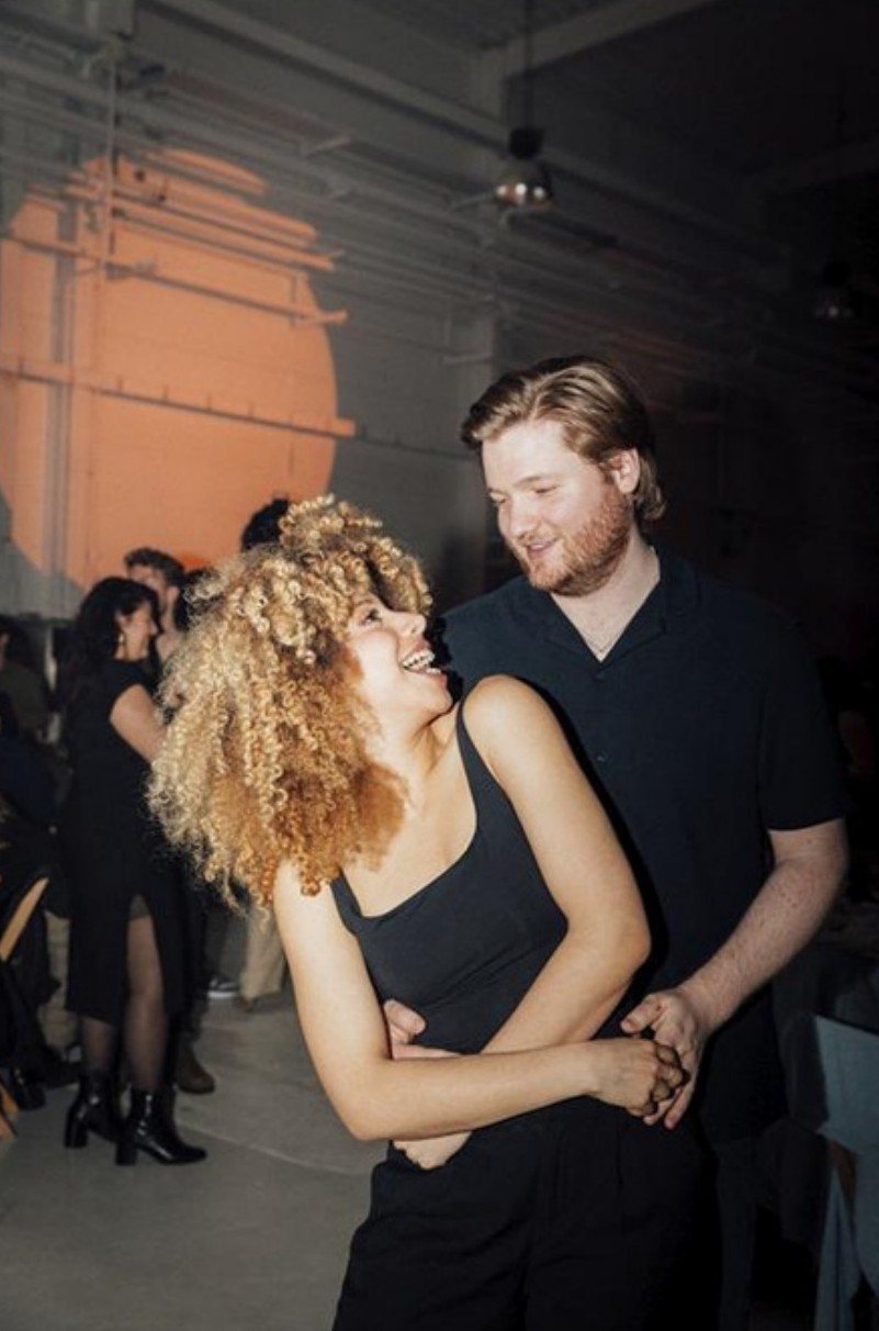Couple laughing on the dance floor at a warehouse party