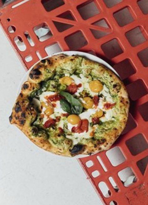 Pesto pizza on a red crate, from above