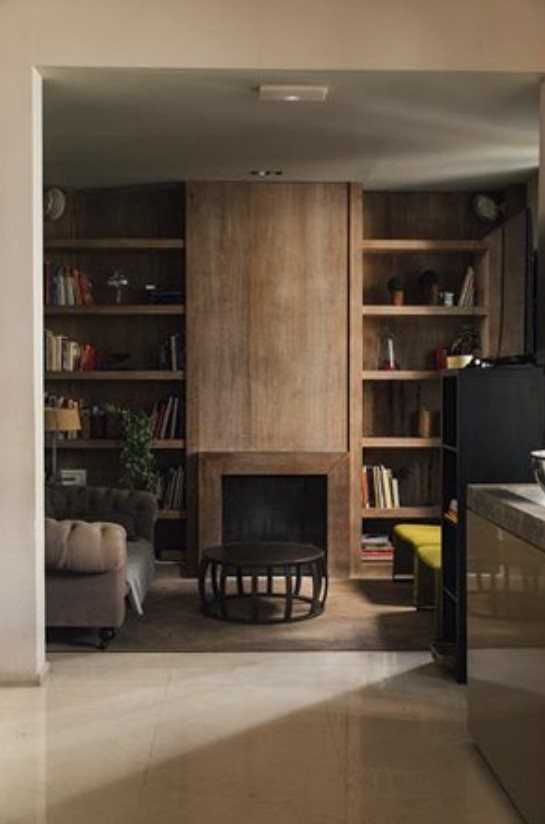 Library corner with fireplace and wooden shelves