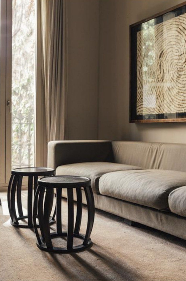 Quiet lounge with linen sofa and black rattan stools