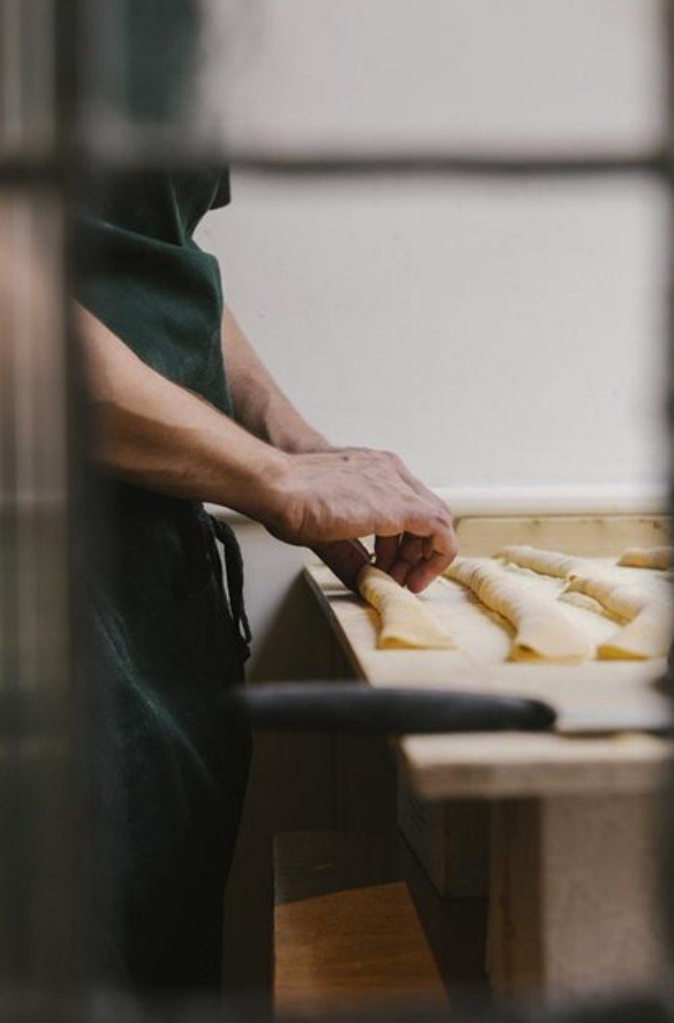 Cook folding fresh pasta by the window