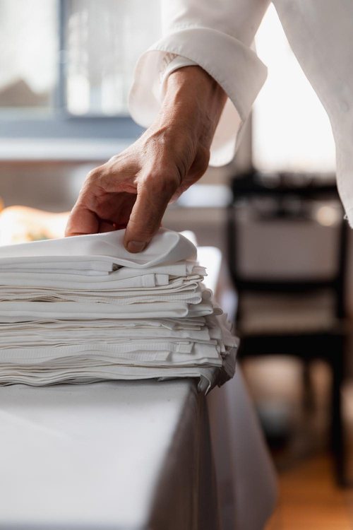 Hand smoothing a stack of fresh linen napkins