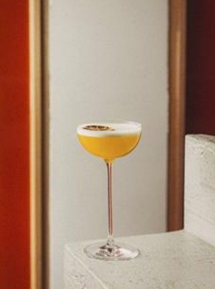 Sour cocktail on a marble ledge against terracotta walls
