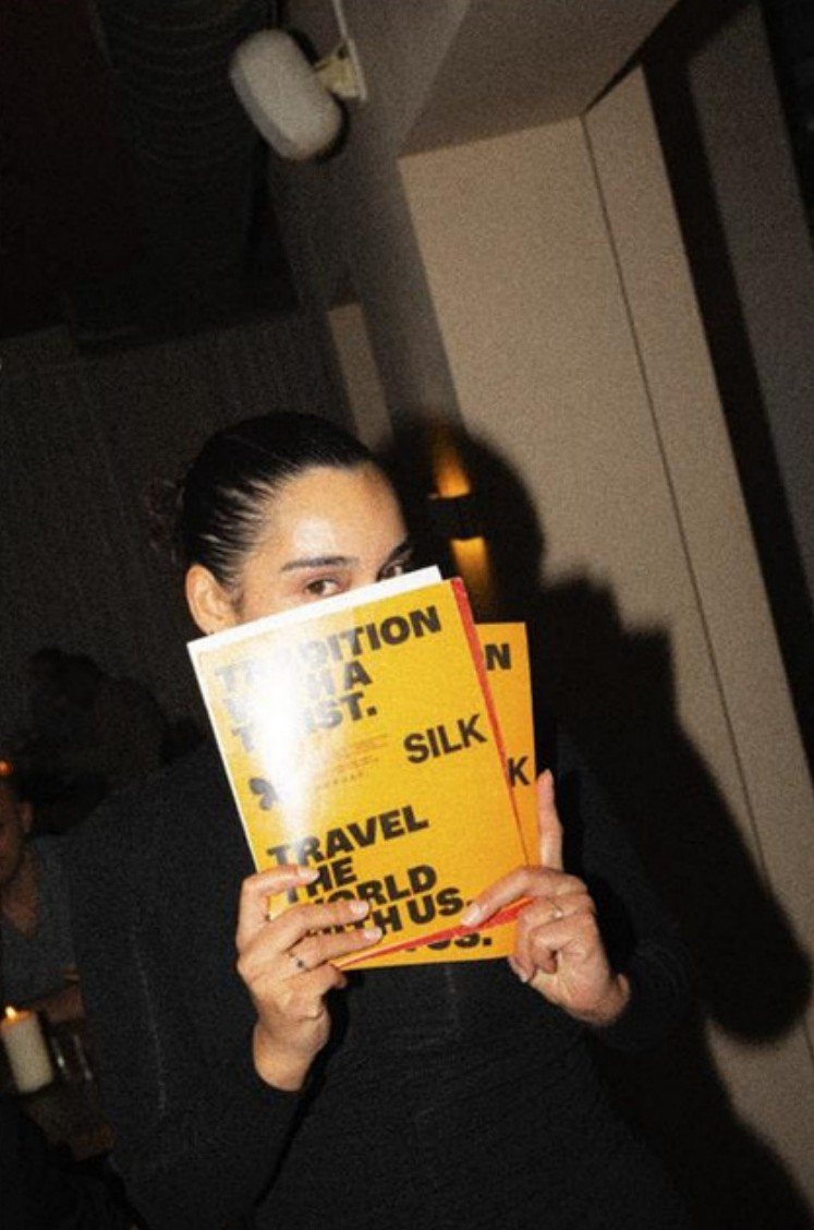 Guest peeking over a SILK magazine at the launch night